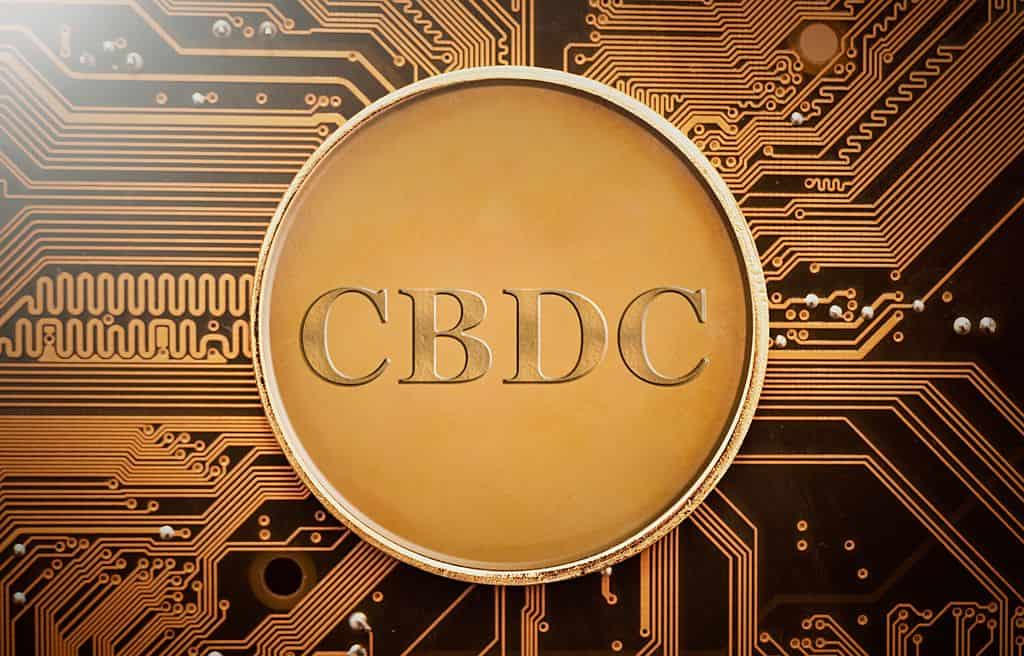 Imagen de una moneda digital con las siglas CBDC sobre un fondo de circuito impreso, representando la tecnología de monedas digitales respaldadas por bancos centrales en la era de las CBDC.